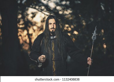 Black magician. A man with long hair. Cosplay Warlock. A creepy guy in a black robe