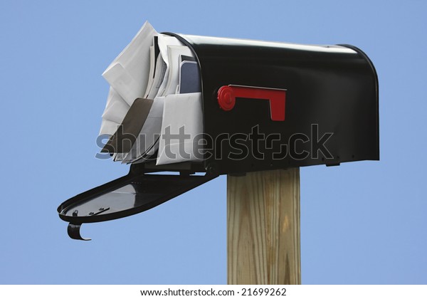 Black\
Mailbox stuffed with junk mail on a blue\
background