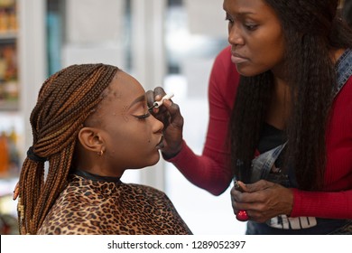 A Black Makeup Artist Apllying Eyeliner On A Beautiful Black Model.