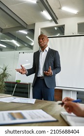 Black Male Boss Gesticulating During Performing Before Employees At Corporate Meeting. Multiethnic People At Coworking Office. Business Cooperation And Teamwork. Idea Of Leadership And Management