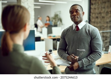 Black Male CEO Talking Female Coworker During A Meeting In The Office.