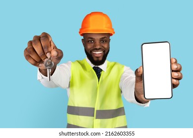 Black Male Civil Engineer In Hardhat Showing Home Keys And Blank Smartphone At Camera, Happy African American Property Developer Advertising Mobile App For Buying Real Estate Online, Mockup