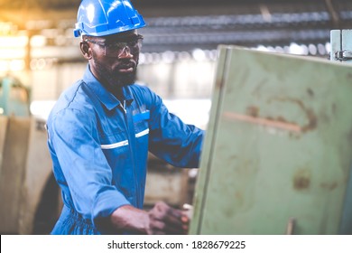 Black Male Engineer Working on machine in Factory. black man engineer checking Quality control the condition of the machine. Service and Maintenance of factory machinery. American African people. - Powered by Shutterstock