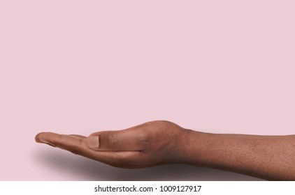 Black Male Hand At Pink Background With Copy Space. Empty Palm Of African-american Man Holding Virtual Object, Asking Or Offering Something. Conceptual Mockup For Ad, Placard Or Motivation Poster