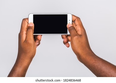 Black Male Hand Touching Mobile Phone Display And Pointing With Index Finger At Blank Screen, Isolated Over White Background, Copy Space, Cutout.