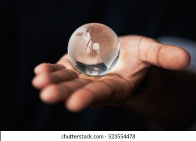 Black Male Hands Holding Glass Earth Model.Concept For Planet Care,ecology And Environment Conservation.Black Guy Hold Earth Globe Model