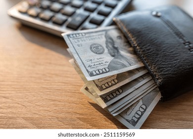 black male leather wallet and us dollar money with calculator on desk. Financial saving concept - Powered by Shutterstock