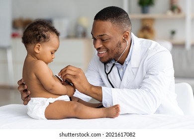 Black Male Pediatrician Listening Infant Child's Heartbeat With Stethoscope During Checkup At Home, Smiling African American Pediatrist Doctor Checking Baby's Heart And Lungs, Closeup Shot