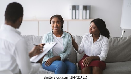 Black male psychologist consulting millennial LGBT couple at clinic, panorama. Psychotherapist having session with young homosexual family at office. Marriage counseling concept - Powered by Shutterstock