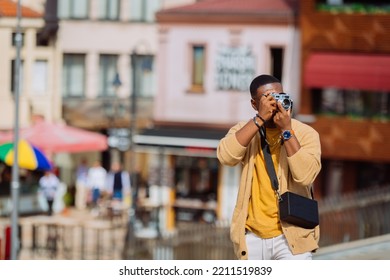 A Black Male Is Standing And Taking Pictures In The Downtown Area