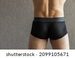 Black male underpants are worn on a young Caucasian man, close-up photo, rear view