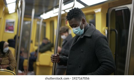 Schwarzer Mann mit verstellbarer Gesichtsmaske fahren mit Zug U-Bahn. unterirdische Person während der Koronavirus-Pandemie