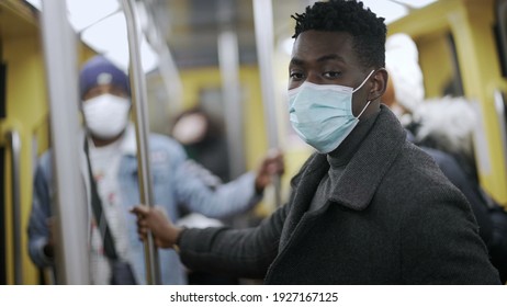 Black man adjusting face mask riding train metro. Person commuting underground during coronavirus pandemic - Powered by Shutterstock