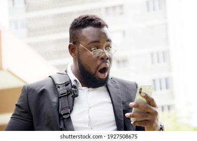 Black Man In Bearded Suit Feeling Surprised And Happy To Receive Fantastic News On His Cell Phone, New Job, Bonus