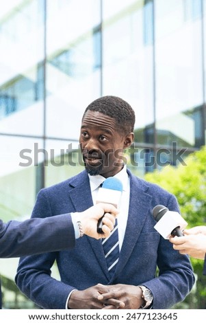Black man being interviewed in front of a building