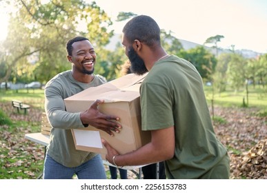 Black man, charity and holding box in park of donation, community service or social responsibility. Happy guy, NGO workers and team helping with package for volunteering, support and society outreach