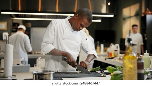 Black man, chef and serious with cutting vegetables in kitchen at restaurant for fine dining, meal or creativity. Male employee, professional or cooker with food for culinary, hospitality or catering - Powered by Shutterstock