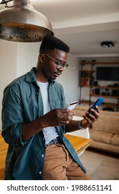 Black Man E-banking With Credit Card And Digital Tablet At Home