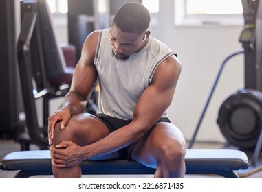 Black Man, Fitness And Knee Injury In Gym After Workout, Training Or Intense Exercise. Earphones, Health And Bodybuilder Male From Nigeria Suffering From Sore Leg, Muscle Pain Or Joint Inflammation.