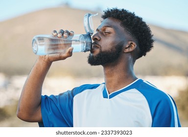 Black man, fitness or soccer player drinking water in training, exercise or workout in football field. Thirsty, sports or tired athlete on resting break with a healthy beverage for energy to relax - Powered by Shutterstock