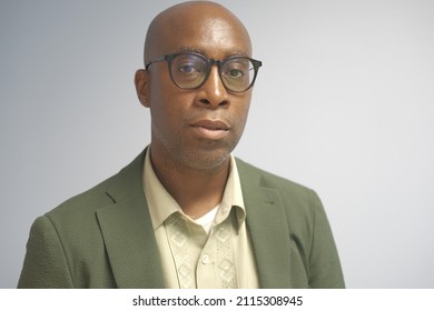 Black Man With Glasses On And Green Suit Jacket. 