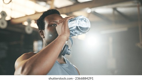 Black man at gym, water bottle and relax to hydrate in muscle development, strong body and fitness. Commitment, motivation and bodybuilder with drink in workout challenge for health and wellness. - Powered by Shutterstock