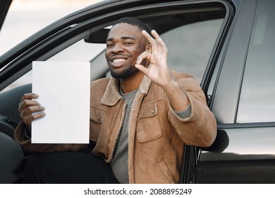 Black man with happy face impression holding sheet of paper