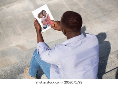 Black Man Having Video Call With Wife And Daughter On Digital Tablet While Sitting Outdoors, Unrecognizable African American Guy Enjoying Remote Communication With His Family, Creative Collage