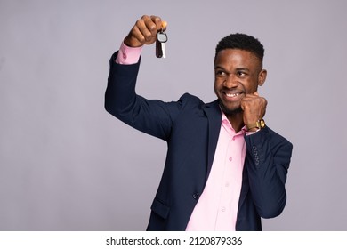black man holding a car key rejoicing