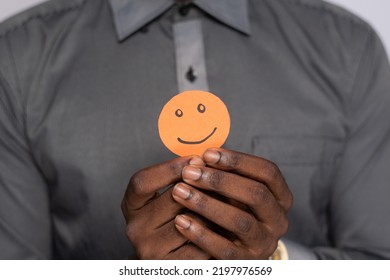 Black Man Holding Cardboard Cutout Smiling Emoji Face