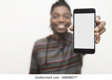 black man holding out hand to show blank white screen of cell phone with clipping path concept. Model is smiling and dressed in casual clothes. 