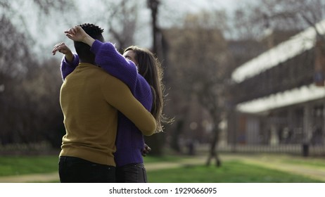 
Black Man Kissing White Girlfriend Standing Outside At Park