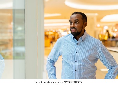 Black Man Looking Through Window While Thinking