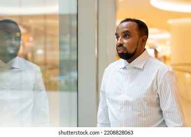 Black Man Looking Through Window While Thinking