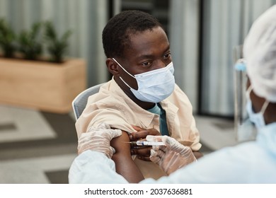 Black Man In Medical Mask Getting Shot Of COVID-19 Vaccine In Hospital