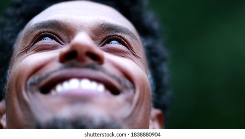 Black man meditating outside taking a deep breath and opening eyes to the sky, person contemplating life - Powered by Shutterstock