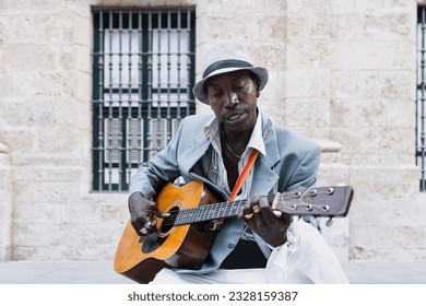 Black Man musician playing guitar on the street in La Havana in Latin America, Afro american and caribbean people - Powered by Shutterstock