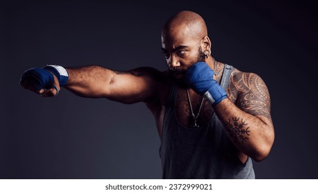 Black man practicing boxing with bandages on hands sore dark background in a studio shot