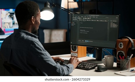 Black man programmer manages code and scripts in artificial intelligence and machine learning on dual monitors computer setup. Male freelancer uses pc to guarantee cyber security. Camera B.