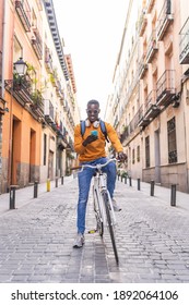 Black Man Riding Bike Using Cellphone Outdoors. African American Young Man Using Phone In The City. Lifestyle Concept.