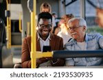 Black man is showing a caucasian senior man his smartphone on the public transport