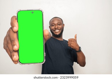 black man showing his phone screen and does a thumbs up - Powered by Shutterstock