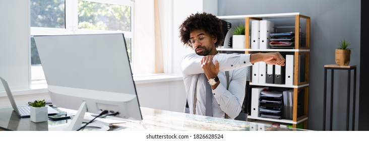 Black Man Stretching At Office Desk At Work