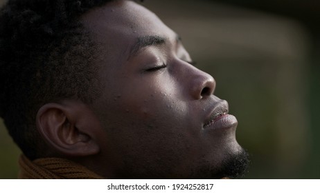 Black Man Taking A Deep Breath Outside And Opening Eyes Looking Up At Sky Smiling Feeling Free