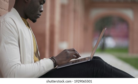 Black Man Typing On Computer Laptop Sitting Outside. African Person Remote Work