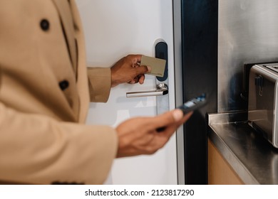 Black Man Using Cellphone While Opening Door At Hotel Indoors