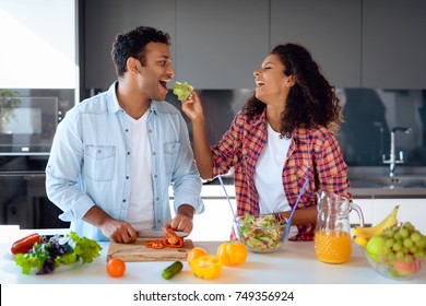 Black man and woman in the kitchen at home. They prepare a tasty and healthy breakfast. They cook together. They are in the modern kitchen. - Shutterstock ID 749356924