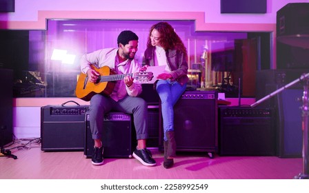 Black man, woman and songwriting with guitar, studio and night with paper for creative lyrics, notes and ideas. Music team, writing and singing together for professional production with teamwork