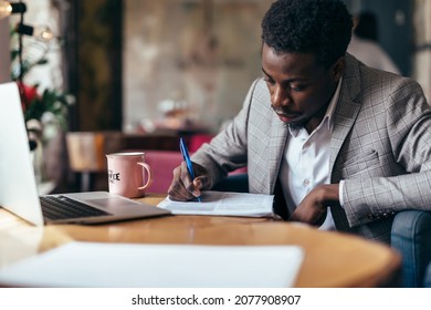 Black man working with documents, writing on paper