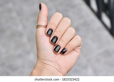 Black Manicured Nails. Nice Hand with Golden Jewelry 